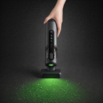 Guu Vision 2.0 cordless handheld vacuum using the green dust-reveal light to illuminate and target hidden dust on the floor.