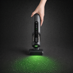 Guu Vision 2.0 cordless handheld vacuum using the green dust-reveal light to illuminate and target hidden dust on the floor.